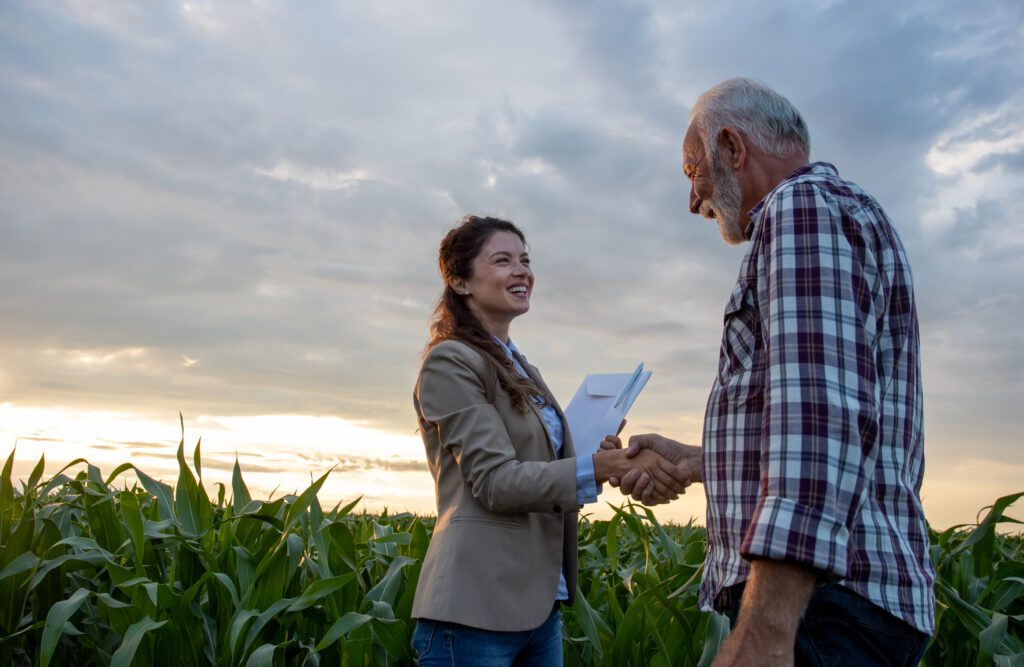 Two people discussing insurance in a field