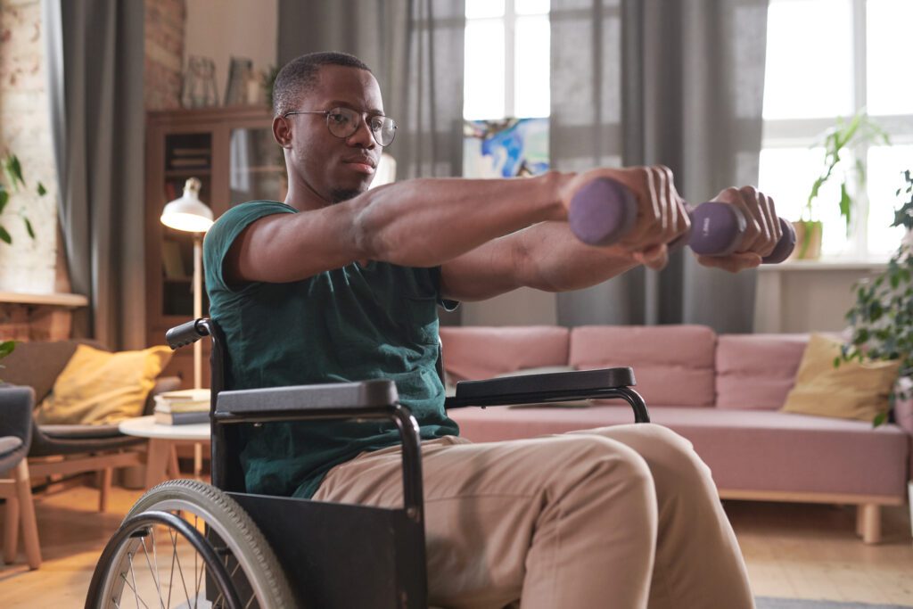 man in wheelchair lifting weights