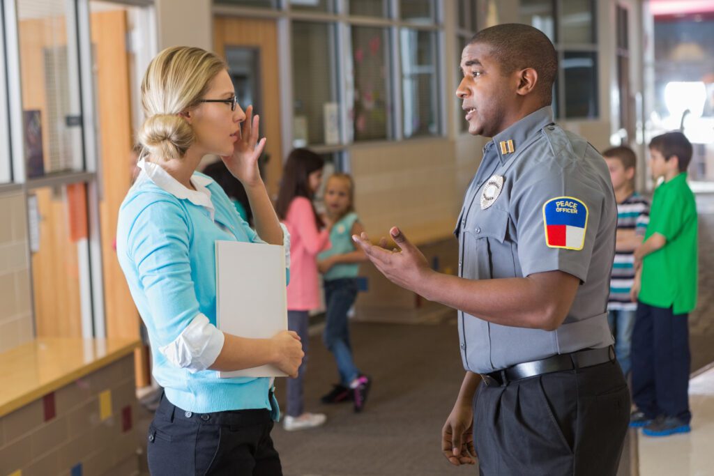 Security officer talking to woman in hallway