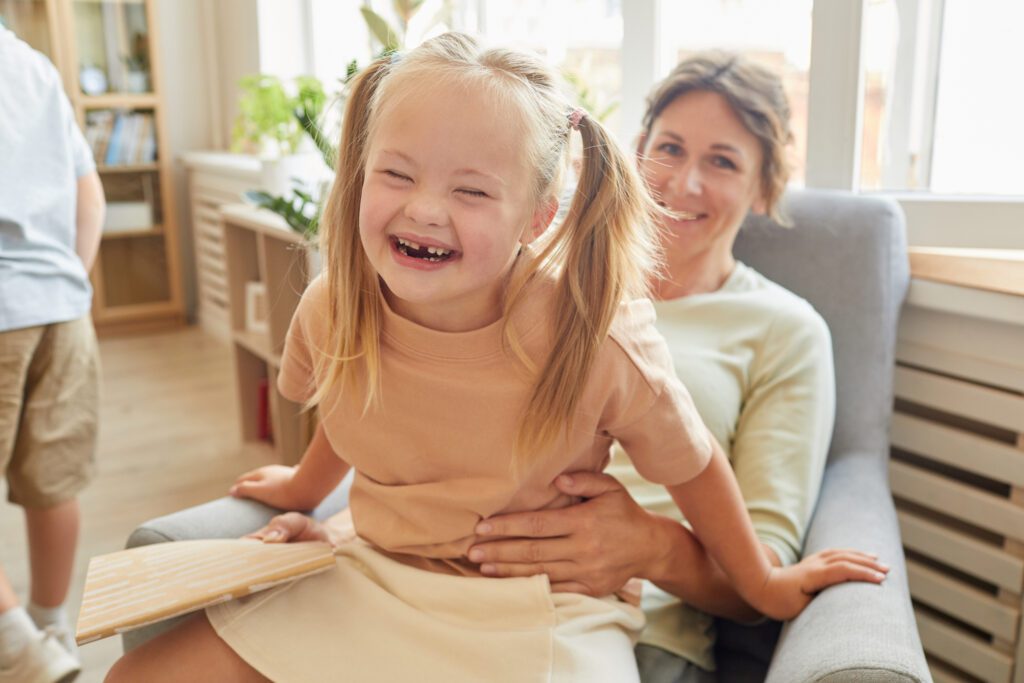 girl sitting on adult's lap laughing and having fun