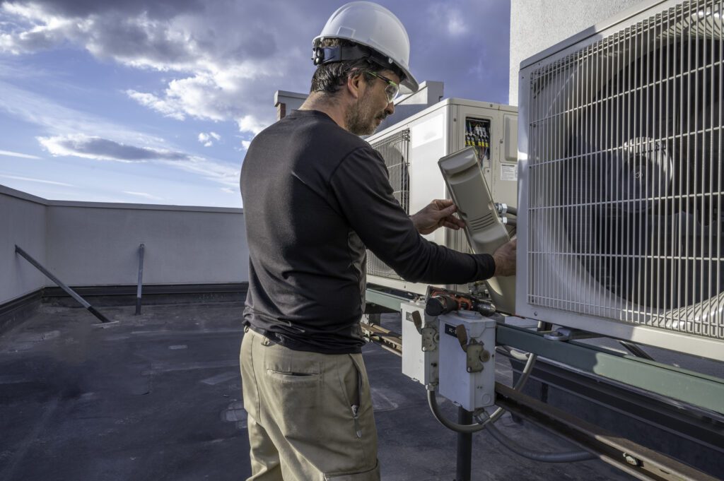 Man on roof working on HVAC equipment