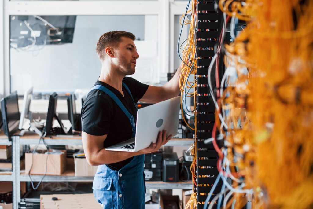 man at rack of computer servers